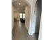 Inviting home hallway leading to a living room with a black leather couch at 18417 Oliver Twist Way, Winter Garden, FL 34787