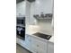 Kitchen area showcasing stainless steel appliances, white cabinetry and a subway tile backsplash at 18417 Oliver Twist Way, Winter Garden, FL 34787