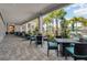 Covered outdoor patio featuring tables and chairs, with views of the pool and palm trees at 18417 Oliver Twist Way, Winter Garden, FL 34787