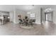 Dining area with wood-look tile flooring, chandelier, table with chairs, and access to the kitchen at 18955 Rawson St, Orlando, FL 32827