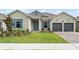 Charming single-story home featuring blue shutters, a manicured lawn, and a two-car garage at 18955 Rawson St, Orlando, FL 32827