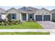 Charming single-story home featuring blue shutters, a manicured lawn, and a two-car garage at 18955 Rawson St, Orlando, FL 32827