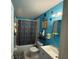 Bathroom features a tub with shower curtain, toilet, and single sink vanity in bright blue at 2224 Patterson Ave, Orlando, FL 32811