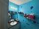 Bathroom features a single sink vanity and open shelving with bright blue walls and floral decoration at 2224 Patterson Ave, Orlando, FL 32811