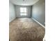 Empty bedroom featuring neutral carpet, paint, and a large window with a view at 231 Riverside Dr # 1510-1, Daytona Beach, FL 32117