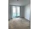 Spacious carpeted bedroom with a large window overlooking city views at 231 Riverside Dr # 1510-1, Daytona Beach, FL 32117