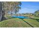 View of backyard pond surrounded by lush green grass and mature trees, creating a tranquil outdoor space at 248 Isle Of Sky Cir, Orlando, FL 32828