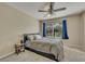 Well-lit bedroom featuring a bed, a ceiling fan, and a view of the backyard at 248 Isle Of Sky Cir, Orlando, FL 32828