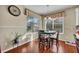 Sunlit dining area featuring wood floors, a round table with four chairs and two large windows with blinds at 248 Isle Of Sky Cir, Orlando, FL 32828