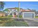 Charming two-story home with a red front door, a manicured lawn, and a two car garage at 248 Isle Of Sky Cir, Orlando, FL 32828