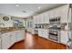 Bright kitchen features stainless steel appliances, granite counters, white cabinetry and an adjacent dining area at 248 Isle Of Sky Cir, Orlando, FL 32828