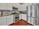 Modern kitchen with stainless steel appliances, granite countertops, white cabinets, and tile backsplash at 248 Isle Of Sky Cir, Orlando, FL 32828