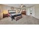 Spacious main bedroom featuring a ceiling fan, dresser with mirror, and an ensuite bathroom at 248 Isle Of Sky Cir, Orlando, FL 32828