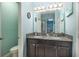 Bathroom with a dual sink vanity, granite countertops, and a large mirror with decorative lighting at 2797 Monticello Way, Kissimmee, FL 34741