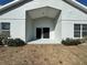 A back patio of the home with bushes in the backyard and a sliding glass door at 2932 Trema Ave, Winter Haven, FL 33881