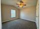 Carpeted bedroom with neutral walls, standard window, lighted ceiling fan and door to adjacent area at 2932 Trema Ave, Winter Haven, FL 33881