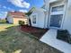 Front yard of gray two-story home features palm tree, mulched flower beds and walkway to front door at 2932 Trema Ave, Winter Haven, FL 33881