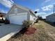 Gray home with two car garage, landscaped flower bed in front and partial side yard view at 2932 Trema Ave, Winter Haven, FL 33881