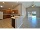 Open kitchen with wood cabinetry, white appliances, breakfast bar, and sliding door access to backyard at 2932 Trema Ave, Winter Haven, FL 33881