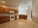 Spacious kitchen features tile floor, wood cabinets and modern white appliances at 2932 Trema Ave, Winter Haven, FL 33881