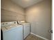 A bright laundry room featuring a washer, dryer, and shelving for storage at 2932 Trema Ave, Winter Haven, FL 33881