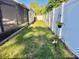 Backyard with white vinyl fencing, green lawn and a view of a screened in patio and a hammock at 322 N Shadowbay Blvd, Longwood, FL 32779