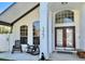 Inviting front entry of a home with rocking chairs and decorative arched windows at 322 N Shadowbay Blvd, Longwood, FL 32779