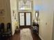 Warm entryway featuring wood floors, decorative mirror, and transom windows at 322 N Shadowbay Blvd, Longwood, FL 32779