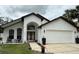 Charming home featuring a stucco exterior, arched entryway, well-manicured lawn, and attached two-car garage at 322 N Shadowbay Blvd, Longwood, FL 32779