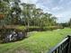 Scenic view of a green pond surrounded by lush natural landscaping and trees, viewed from the backyard at 322 N Shadowbay Blvd, Longwood, FL 32779