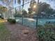 Well-maintained tennis court with a surrounding fence and manicured landscaping at 322 N Shadowbay Blvd, Longwood, FL 32779