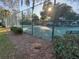 Well maintained tennis court with green surface, surrounded by trees and secure fencing for community recreation at 322 N Shadowbay Blvd, Longwood, FL 32779