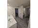 Bathroom featuring double sinks, white cabinets, gray tile flooring, and doorways to other rooms at 3223 Evenmore Way, Wildwood, FL 34785