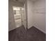 Carpeted walk-in closet with installed shelving seen from a doorway with connected bathroom at 3223 Evenmore Way, Wildwood, FL 34785