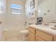 Clean bathroom with a tiled tub, toilet, and vanity with a bright window at 323 Villa Sorrento Cir, Haines City, FL 33844