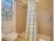 Tiled shower with modern showerhead, complemented by neutral-toned tiles and fixtures at 323 Villa Sorrento Cir, Haines City, FL 33844