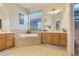 Well-lit bathroom with separate vanities, garden tub, and tile flooring at 323 Villa Sorrento Cir, Haines City, FL 33844