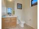 Bright half bathroom with a vanity sink, white toilet, and tiled flooring at 323 Villa Sorrento Cir, Haines City, FL 33844