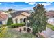 Charming home featuring manicured landscaping, a tile roof, and a quaint front yard with lush green foliage at 323 Villa Sorrento Cir, Haines City, FL 33844