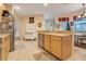 Bright kitchen with wooden cabinets, an island counter and adjacent dining area with a vintage farmhouse table at 323 Villa Sorrento Cir, Haines City, FL 33844