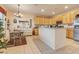 Bright kitchen with wooden cabinets, an island counter and adjacent dining area with a vintage farmhouse table at 323 Villa Sorrento Cir, Haines City, FL 33844