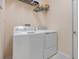 Bright laundry room featuring a white washer and dryer set and a wire shelf with storage at 323 Villa Sorrento Cir, Haines City, FL 33844