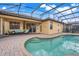 Inviting backyard pool area with screened enclosure, brick pavers, and outdoor seating at 323 Villa Sorrento Cir, Haines City, FL 33844