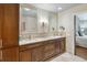 Elegant bathroom featuring double sinks, modern fixtures, and wood cabinetry with access to the main bedroom at 3262 Amaca Cir, Orlando, FL 32837