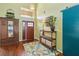 Bright foyer with hardwood floors, featuring a wooden armoire and plants on a console table at 3262 Amaca Cir, Orlando, FL 32837