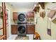 Efficient laundry room includes modern stacked washer and dryer, cabinetry and shelving with stylish decor at 3262 Amaca Cir, Orlando, FL 32837