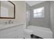 Bathroom with modern vanity, toilet, tiled shower, and a window at 3778 Martin St, Orlando, FL 32806