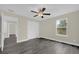 Cozy bedroom with dark wood-look flooring, ceiling fan, and ample light from the window at 3778 Martin St, Orlando, FL 32806