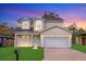 Charming two-story home with an attached two-car garage and neatly manicured lawn and dusk sky at 3778 Martin St, Orlando, FL 32806