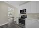 Well-lit kitchen with stainless steel appliances, white countertops, and white cabinets, with view to living room at 3778 Martin St, Orlando, FL 32806